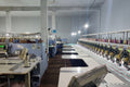 Textile factory interior with sewing machines and equipment.